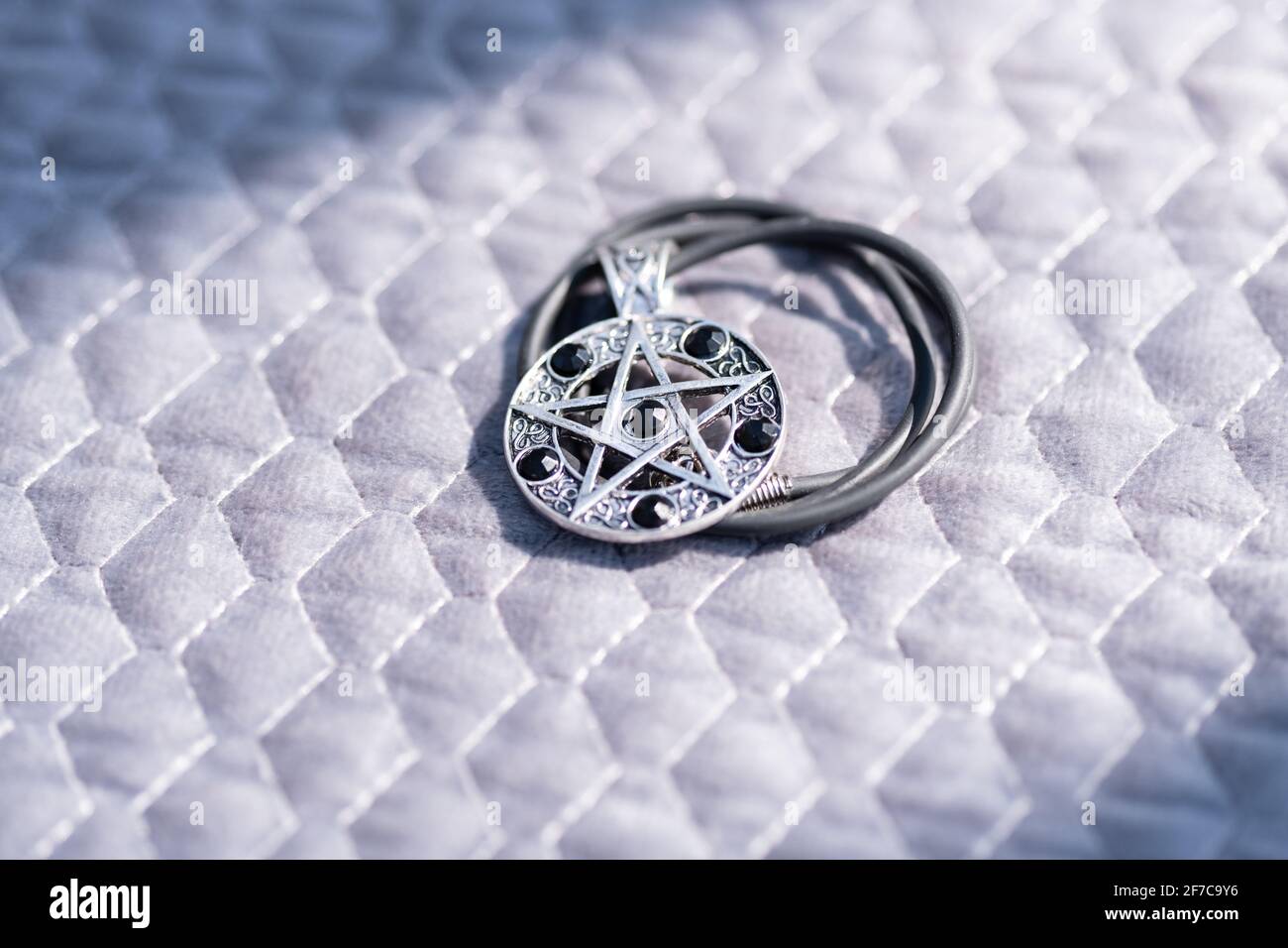 Pendentif Magic Pentagram collier argent et noir acier inoxydable tirer dehors dans un jour d'été gros plan. Banque D'Images