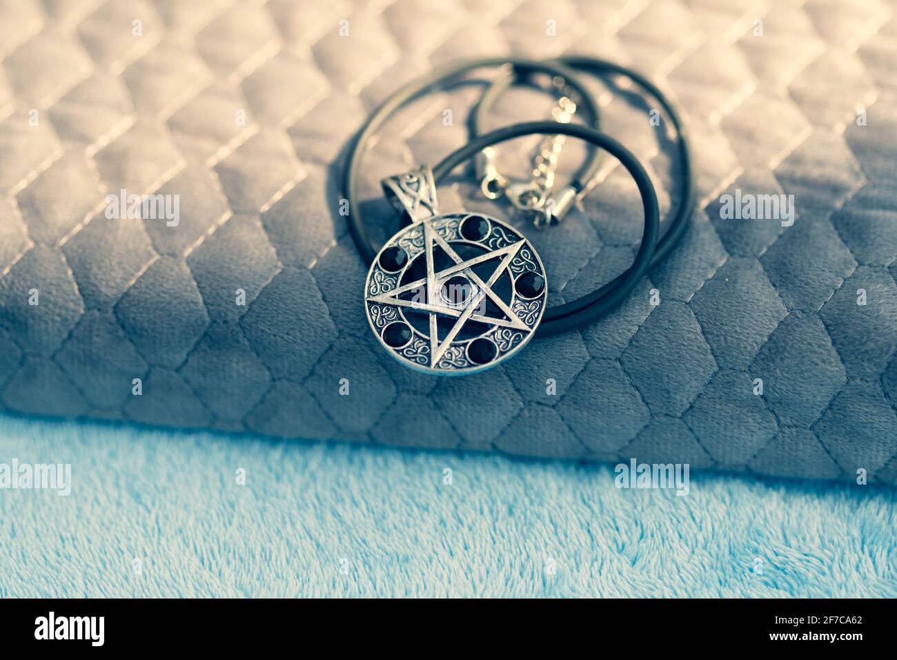 Pendentif Magic Pentagram collier argent et noir acier inoxydable tirer dehors dans un jour d'été gros plan. Banque D'Images