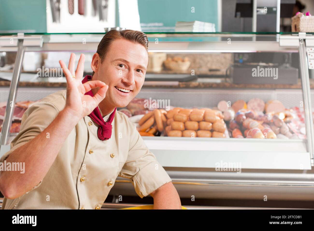 Travailler dans une boucherie - une boucherie est en train de montrer la variété de saucisses Banque D'Images