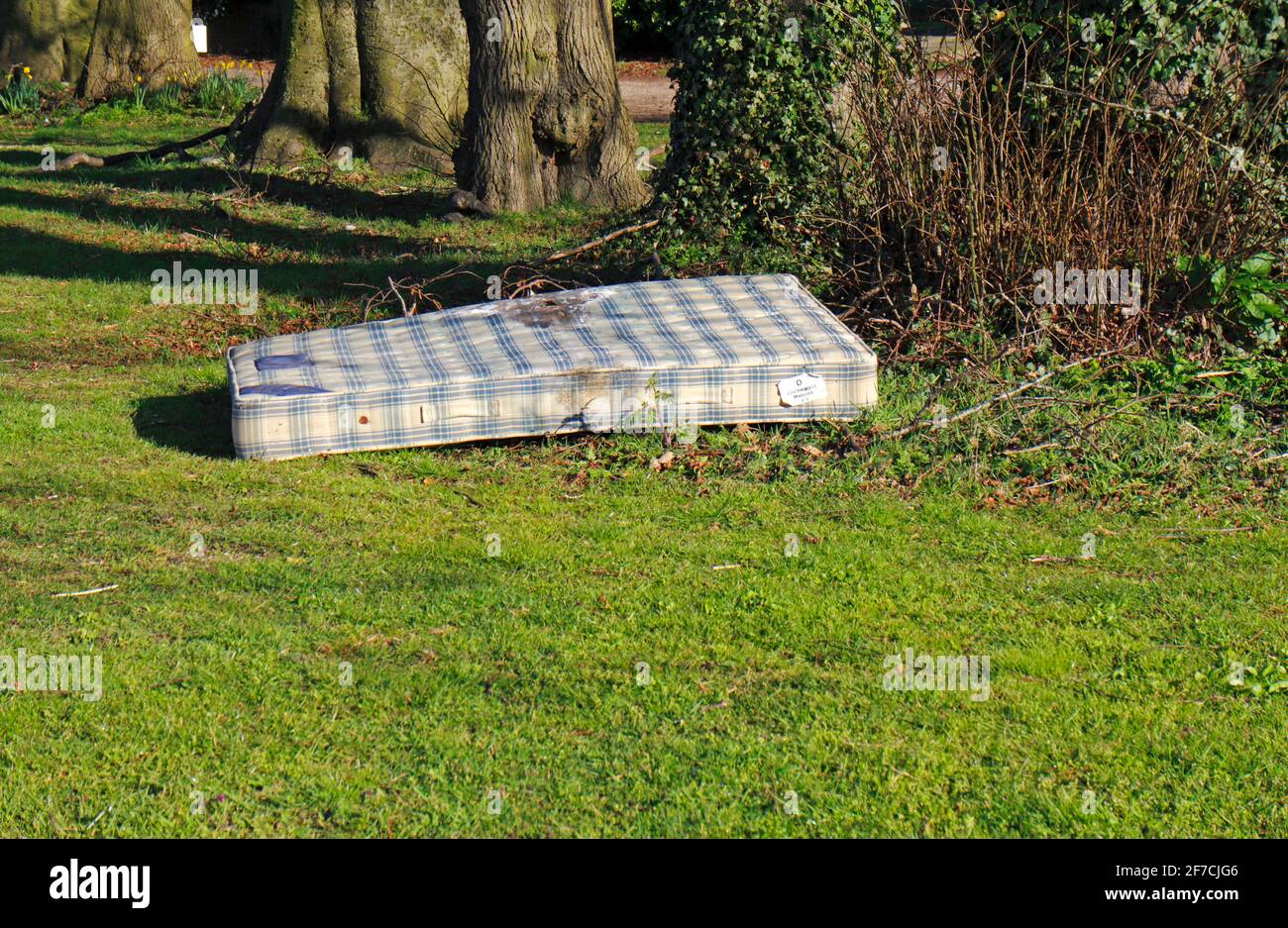 Un matelas à bout de mouche sur un petit vert dans un quartier résidentiel du Borough de Hellesdon, Norfolk, Angleterre, Royaume-Uni. Banque D'Images
