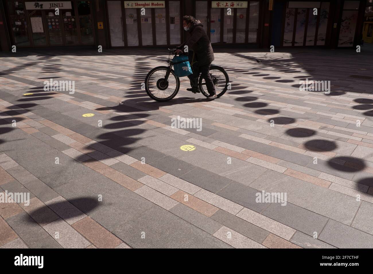 Deliveroo cycliste qui traverse un quartier chinois vide à l'heure du déjeuner Londres Banque D'Images
