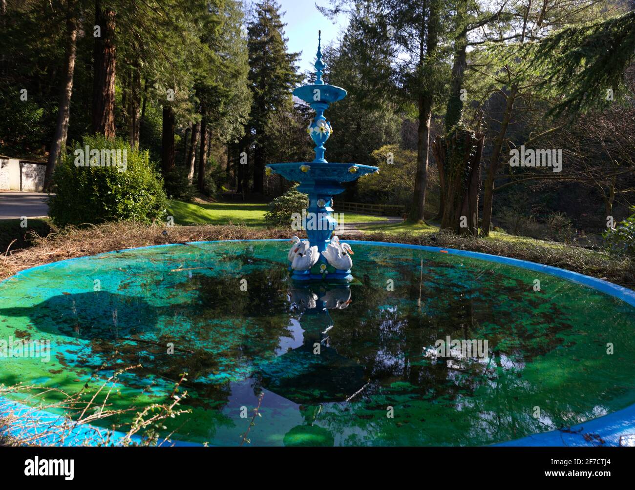 Fontaine en fonte avec cygnes dans l'étang de Glen Helen, dans l'île de Man Banque D'Images