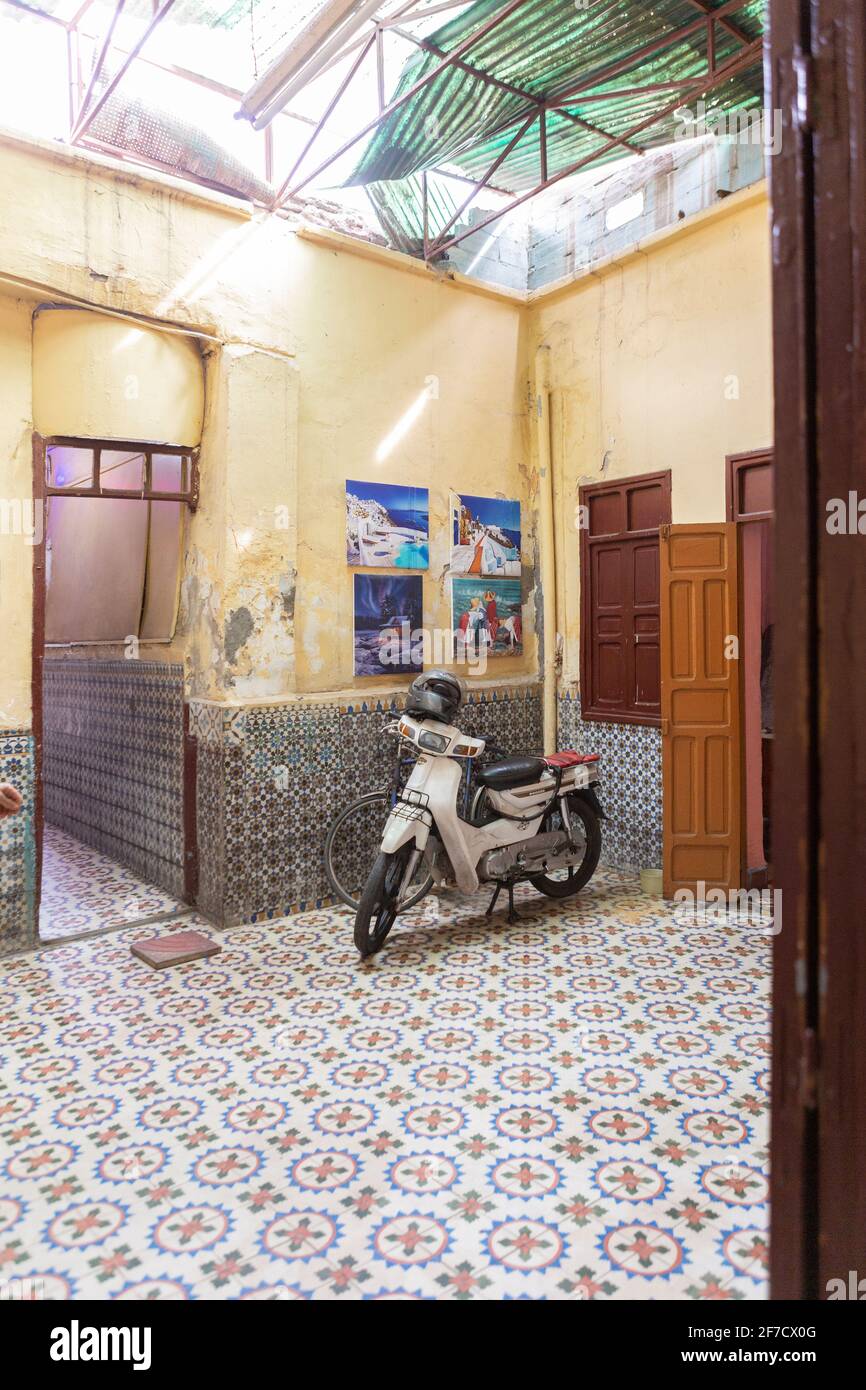Scooter automobile typique dans une cour magnifiquement carrelée à Marrakech, Maroc Banque D'Images