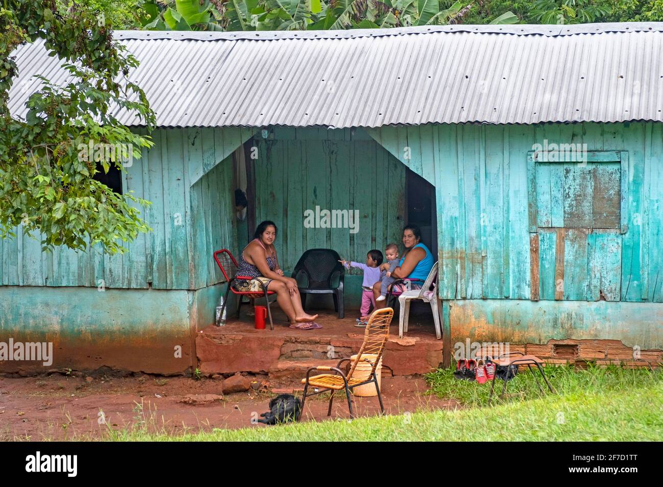 Famille posant dans une cabane en bois avec toit en tôle ondulée dans un village rural près de Ciudad del Este, Alto Paraná, Paraguay Banque D'Images