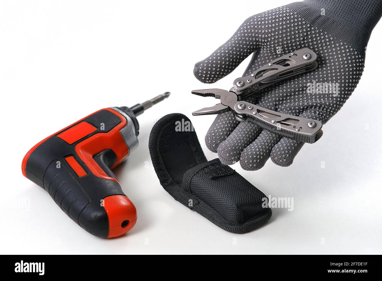 Multi-outils. Un homme démonte les pinces pliantes. En arrière-plan, un tournevis électrique. Un outil pour les petites réparations à domicile Banque D'Images
