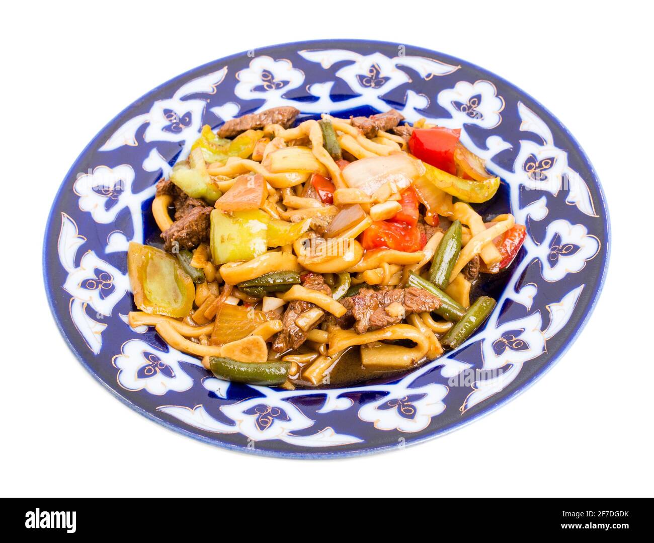 Agneau cuit avec des nouilles de blé et des légumes cuits sur une authentique assiette orientale. Isolé sur un fond blanc. Banque D'Images