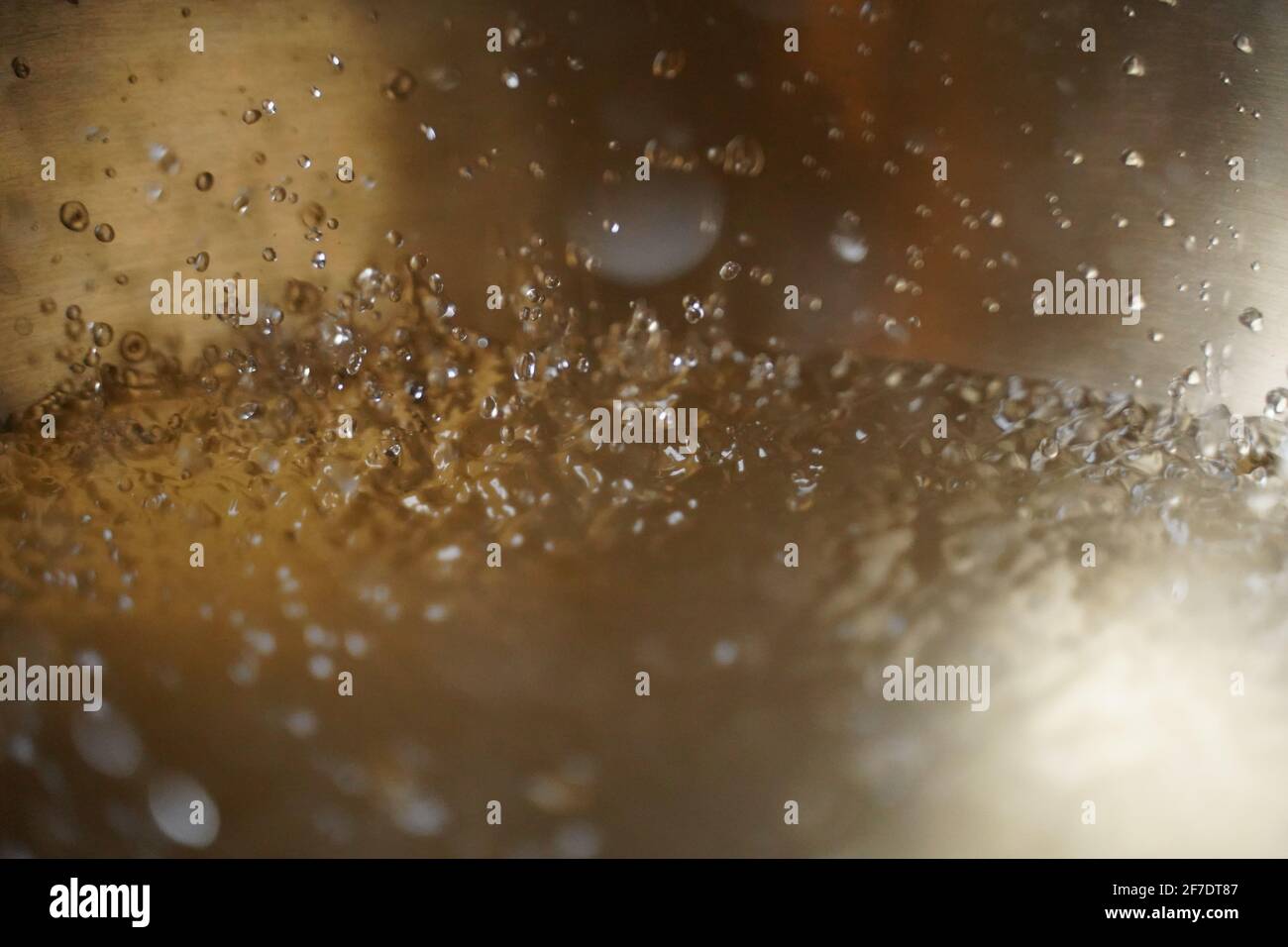 Bol de chant tibétain plein d'eau gros plan sur les gouttes d'eau, instrument de guérison sonore Banque D'Images