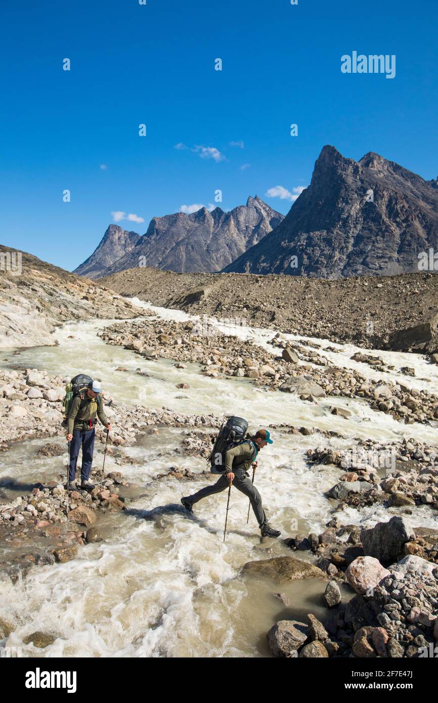 Backpackers traverser une rive de la colère pendant le voyage d'alpinisme. Banque D'Images