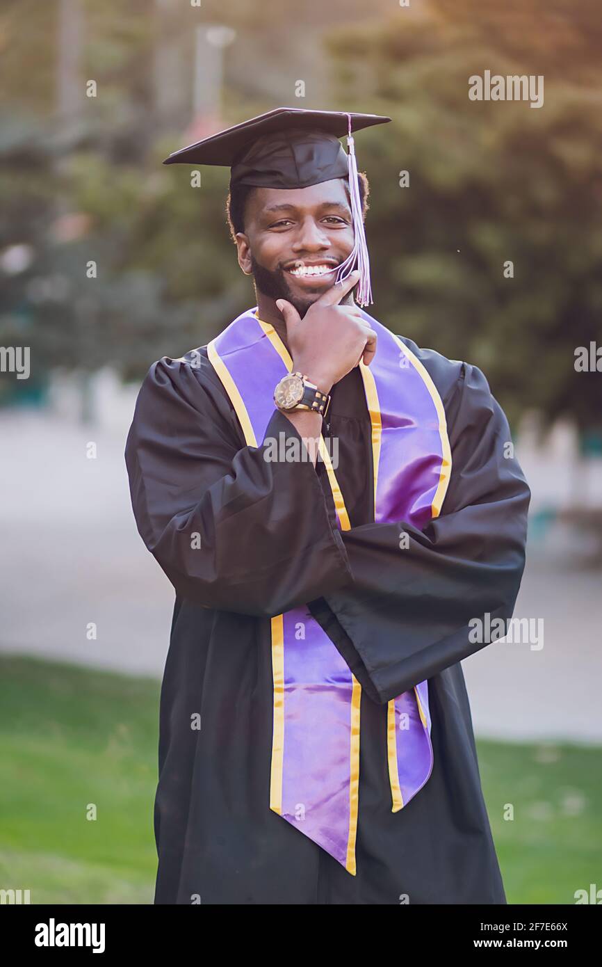 Homme heureux d'être diplômé de l'université, portant une robe de  graduation/chapeau Photo Stock - Alamy