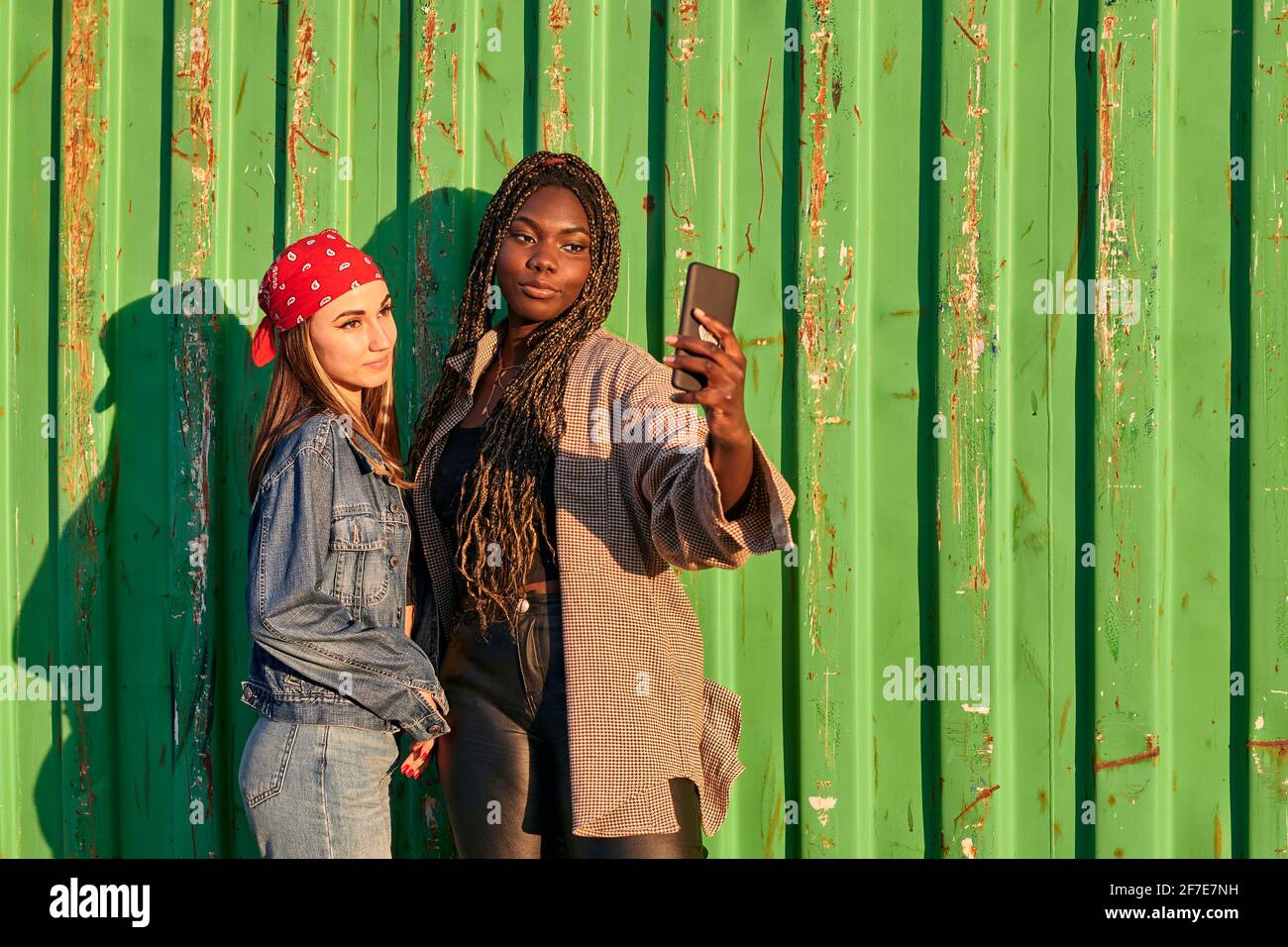 Deux femmes multiethniques en vêtements urbains prennent une photo avec un téléphone Banque D'Images