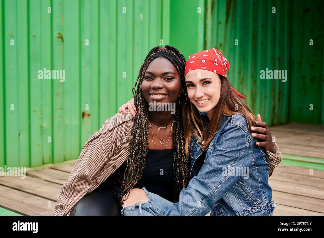 Portrait de deux jeunes femmes multiethniques en vêtements urbains souriant Banque D'Images