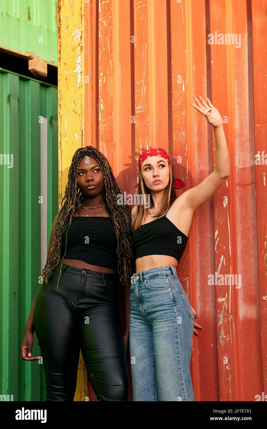 Deux jeunes femmes multiethniques en vêtements urbains posent au coucher du soleil Banque D'Images