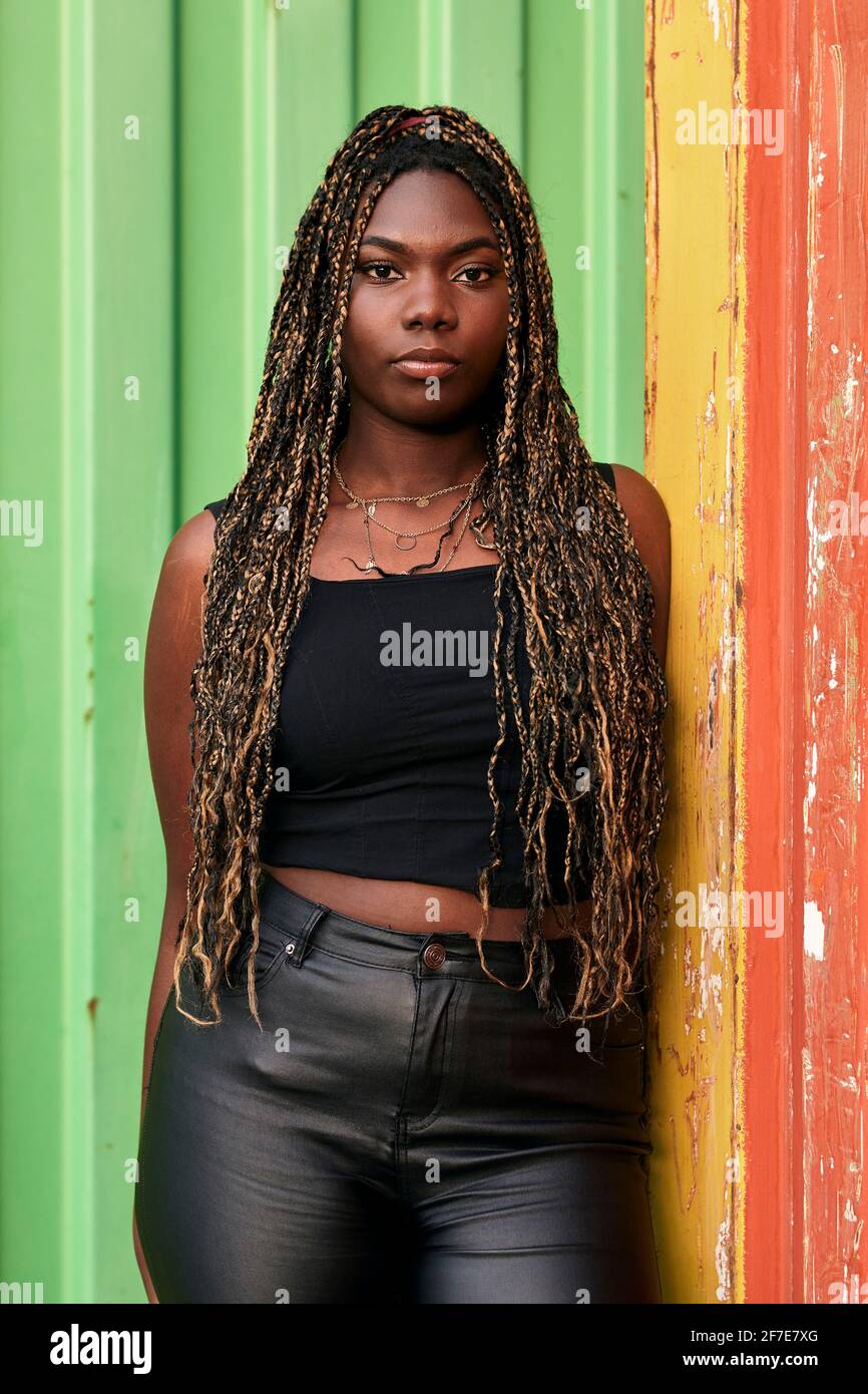 La femme noire avec des tresses et des vêtements urbains est sérieuse la caméra Banque D'Images