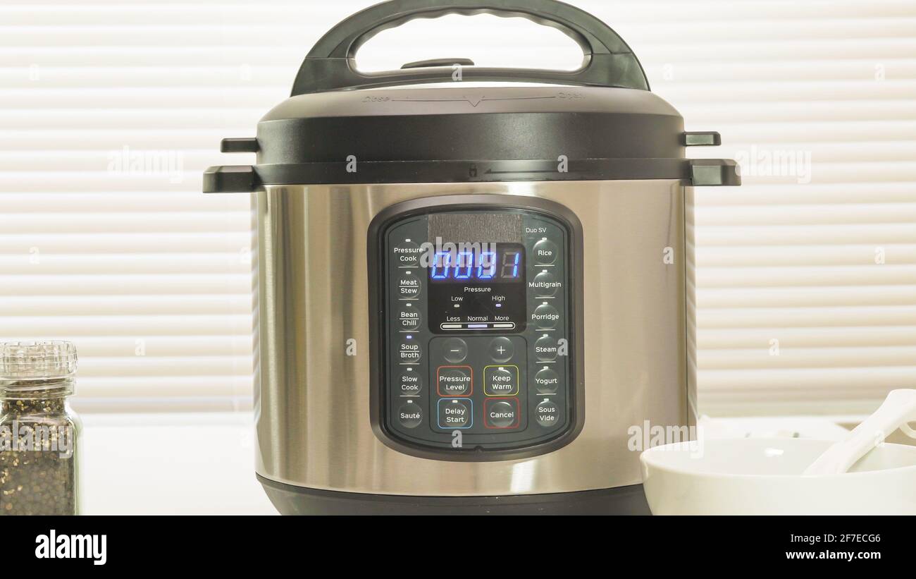 Multi-cuisinière électrique moderne ou cuisinière à pression près de la table de cuisine. Jusqu'à 1 minutes de cuisson restantes Banque D'Images