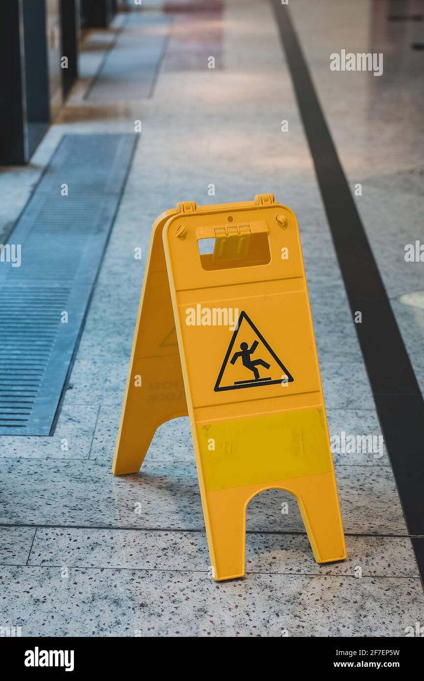 Un panneau d'avertissement jaune sur sol glissant dans un hall au sol en  marbre, informant les gens du sol glissant et humide de la zone Photo Stock  - Alamy