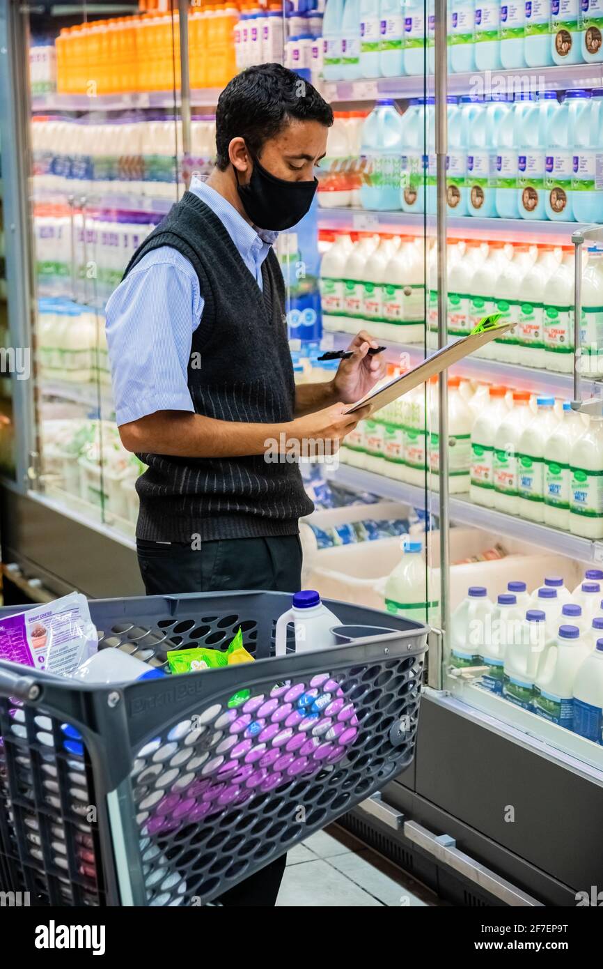 Cape Town, Afrique du Sud - 10 décembre 2020 : membre du personnel qui cueille les produits d'épicerie de l'étagère pour un service de livraison express à domicile au service local Pick n Pay su Banque D'Images