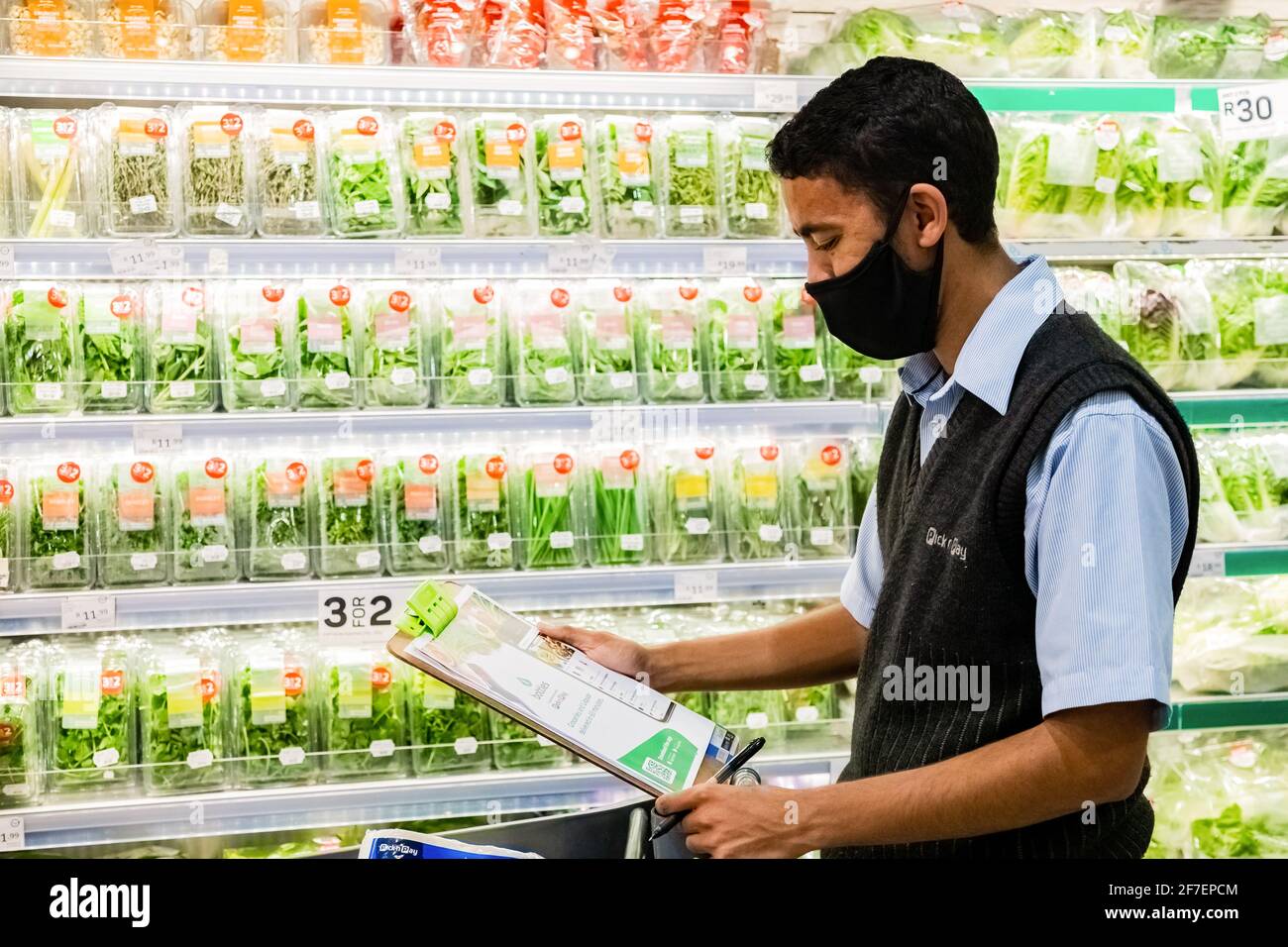 Cape Town, Afrique du Sud - 10 décembre 2020 : membre du personnel qui cueille les produits d'épicerie de l'étagère pour un service de livraison express à domicile au service local Pick n Pay su Banque D'Images