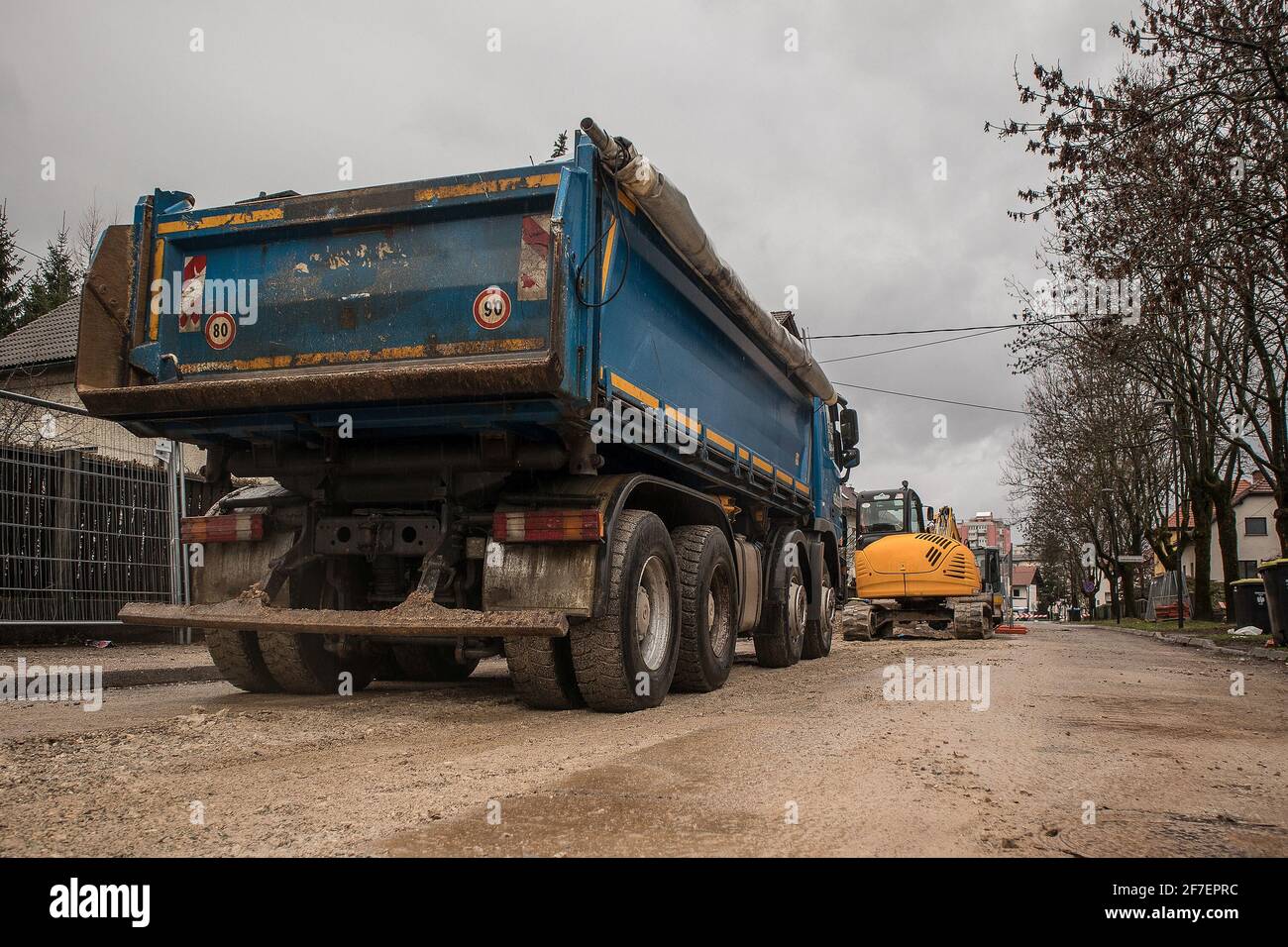 Le camion à benne à quatre essieux bleu de 4 attend son prochain service sur un chantier de construction sur une route urbaine. Vue de l'arrière du chariot. Banque D'Images