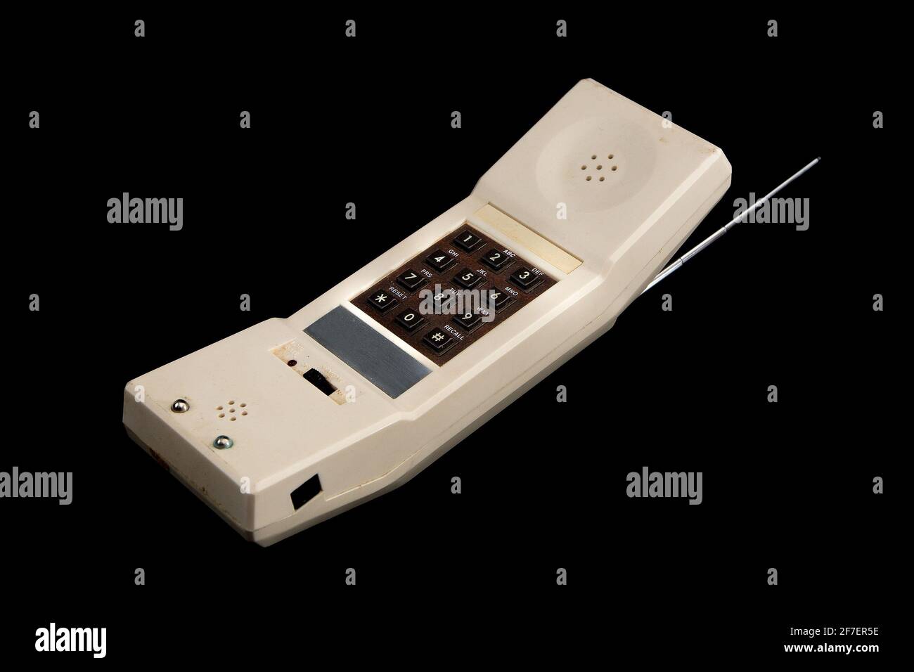 Un ancien téléphone sans fil blanc vintage des années 80 isolé sur noir.  Clavier marron et antenne argent visibles Photo Stock - Alamy