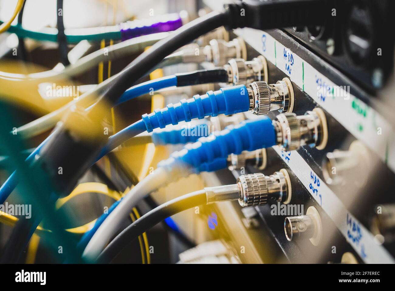 Câbles de signal BNC SDI bleus branchés à l'arrière d'un panneau de raccordement. Un ensemble de câbles visibles derrière le rack ou le panneau. Concentrez-vous sur l'un des connecteurs, ou Banque D'Images