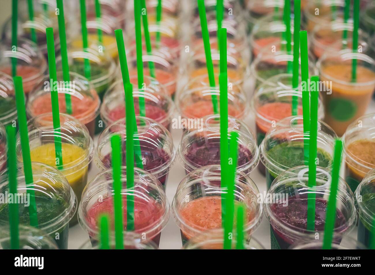 Une multitude de boîtes ou de verres en plastique avec différents smoothies colorés à l'intérieur. Smoothies sur une table au choix. Collection de smoothies en plastique Banque D'Images