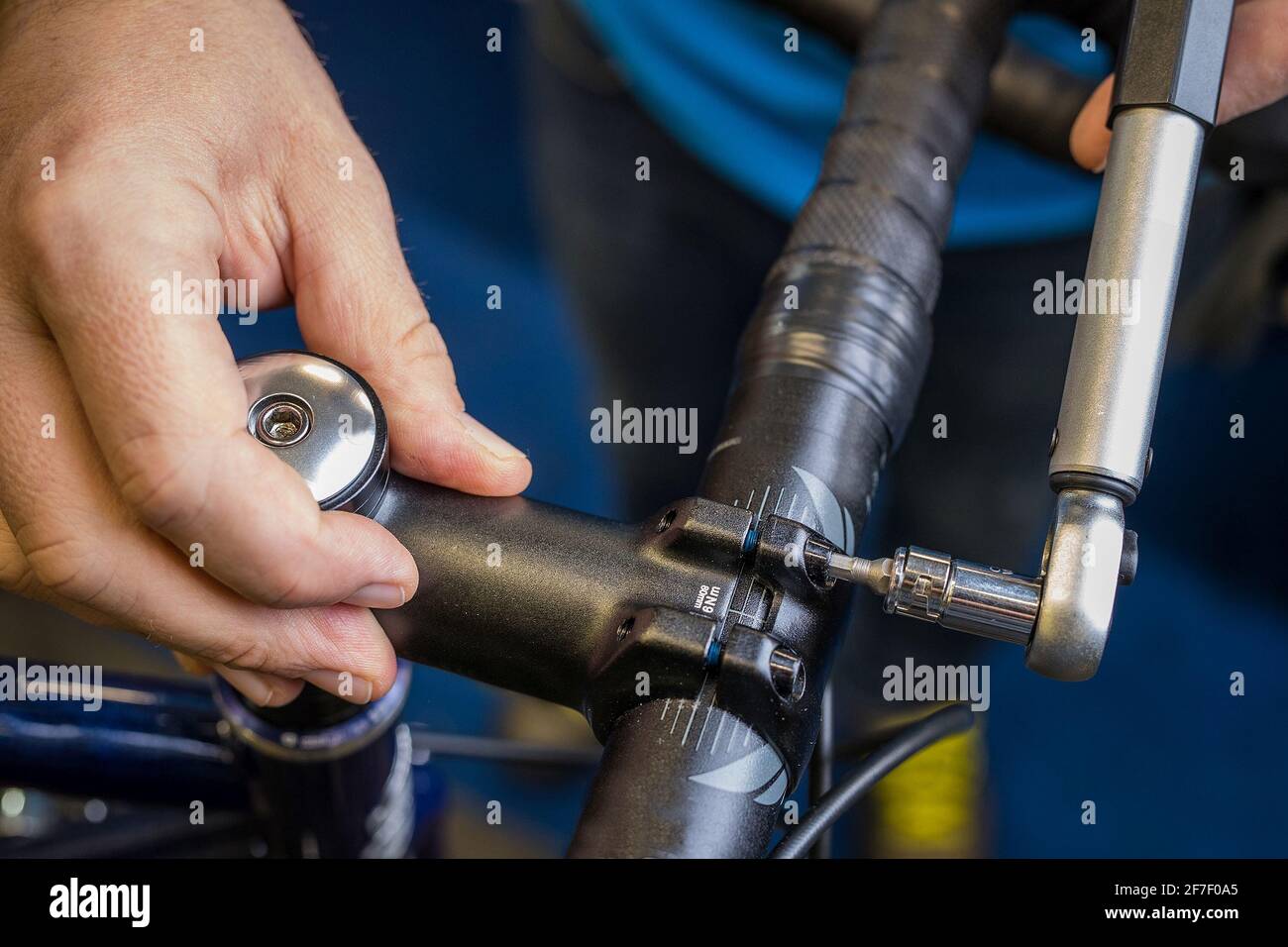 Serrage d'une tige de guidon de vélo à l'aide d'une petite clé  dynamométrique. Méthode appropriée pour serrer le guidon d'un vélo. Service  de vélos dans un atelier de moût Photo Stock -