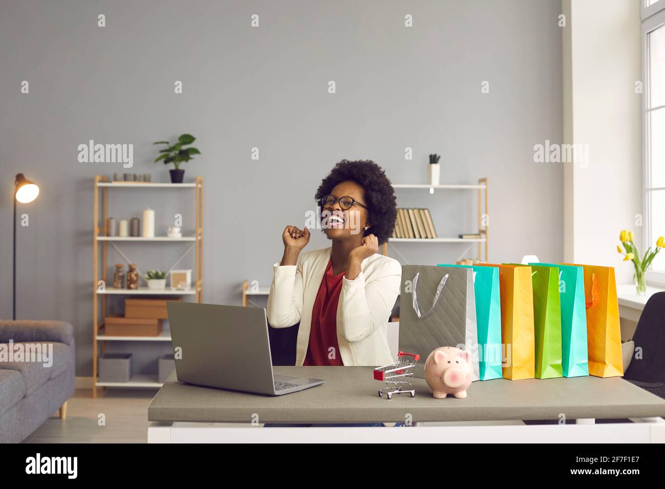 Heureuse femme excitée se réjouit sincèrement qu'elle vient de faire un achat réussi en ligne. Banque D'Images