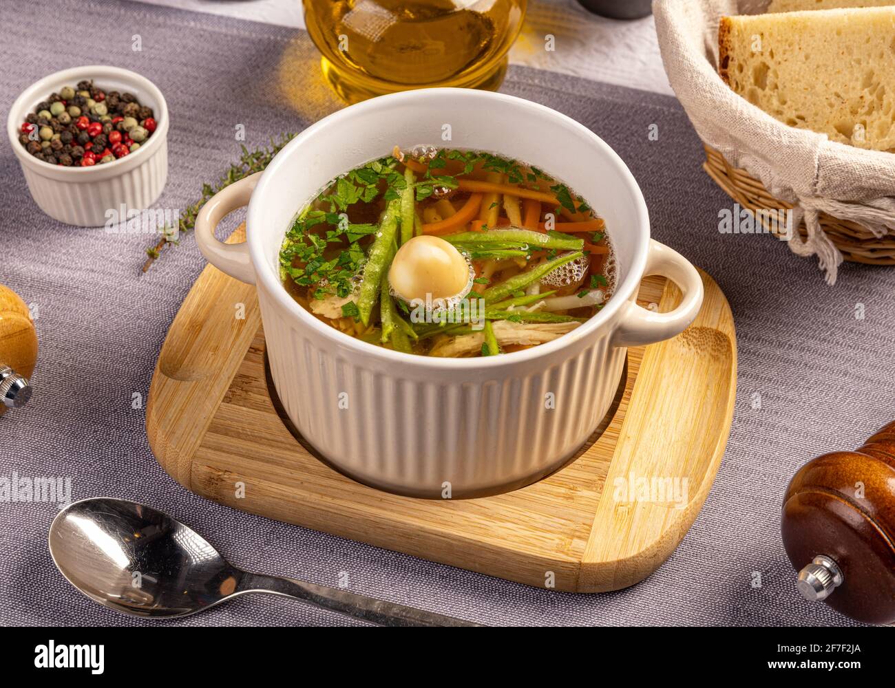 Soupe de poulet aux légumes dans un bol blanc servi avec de la fumée œuf de caille Banque D'Images