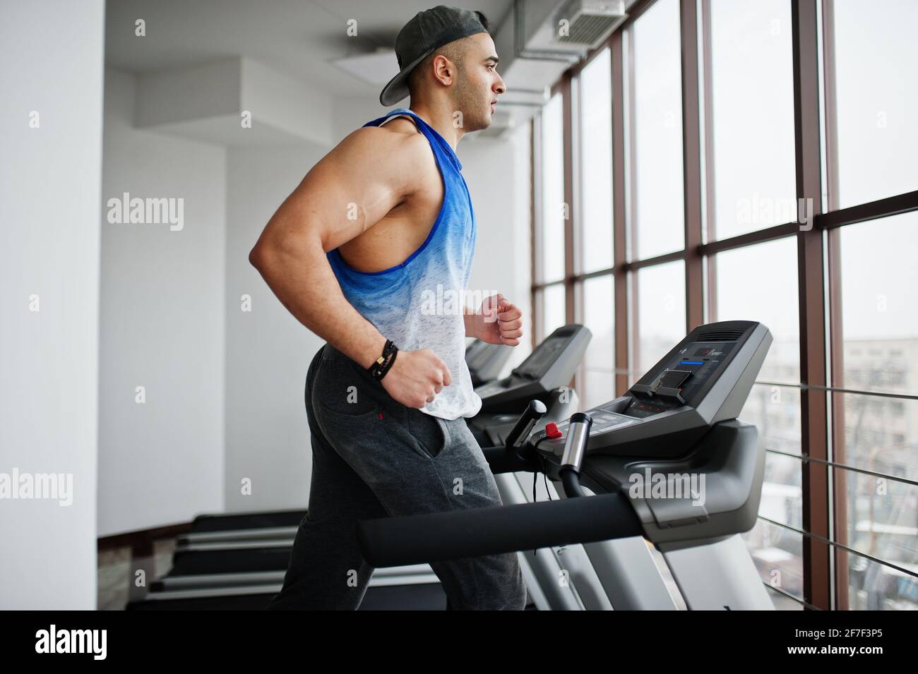 Forme et musclé homme arabe courant sur un tapis roulant dans la salle de  gym Photo Stock - Alamy