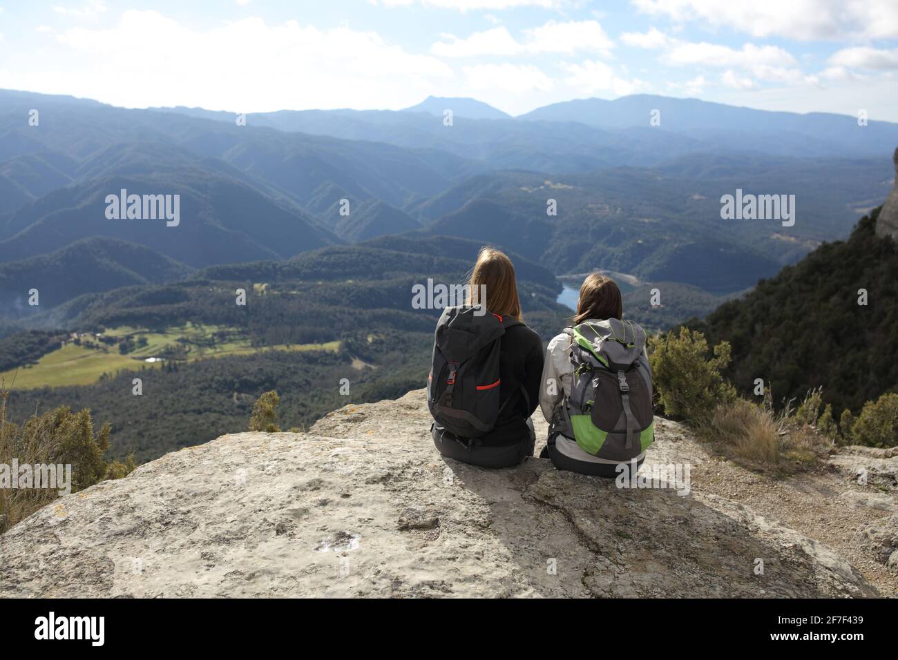 Vue arrière portrait de deux randonneurs se reposant contemplant des vues sur le sommet d'une falaise dans la montagne Banque D'Images