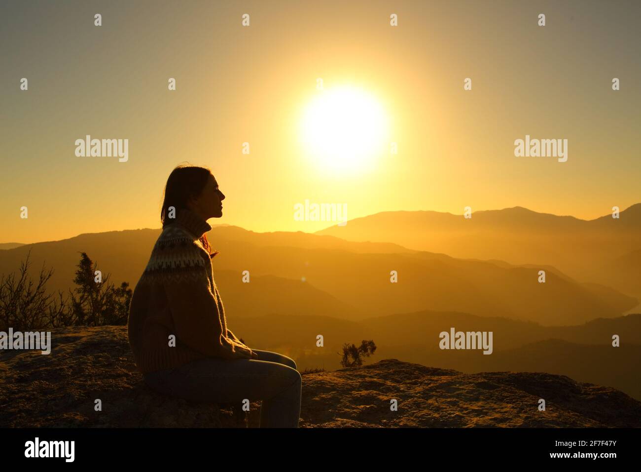 Vue latérale d'une silhouette de femme en train de contempler nature au coucher du soleil Banque D'Images