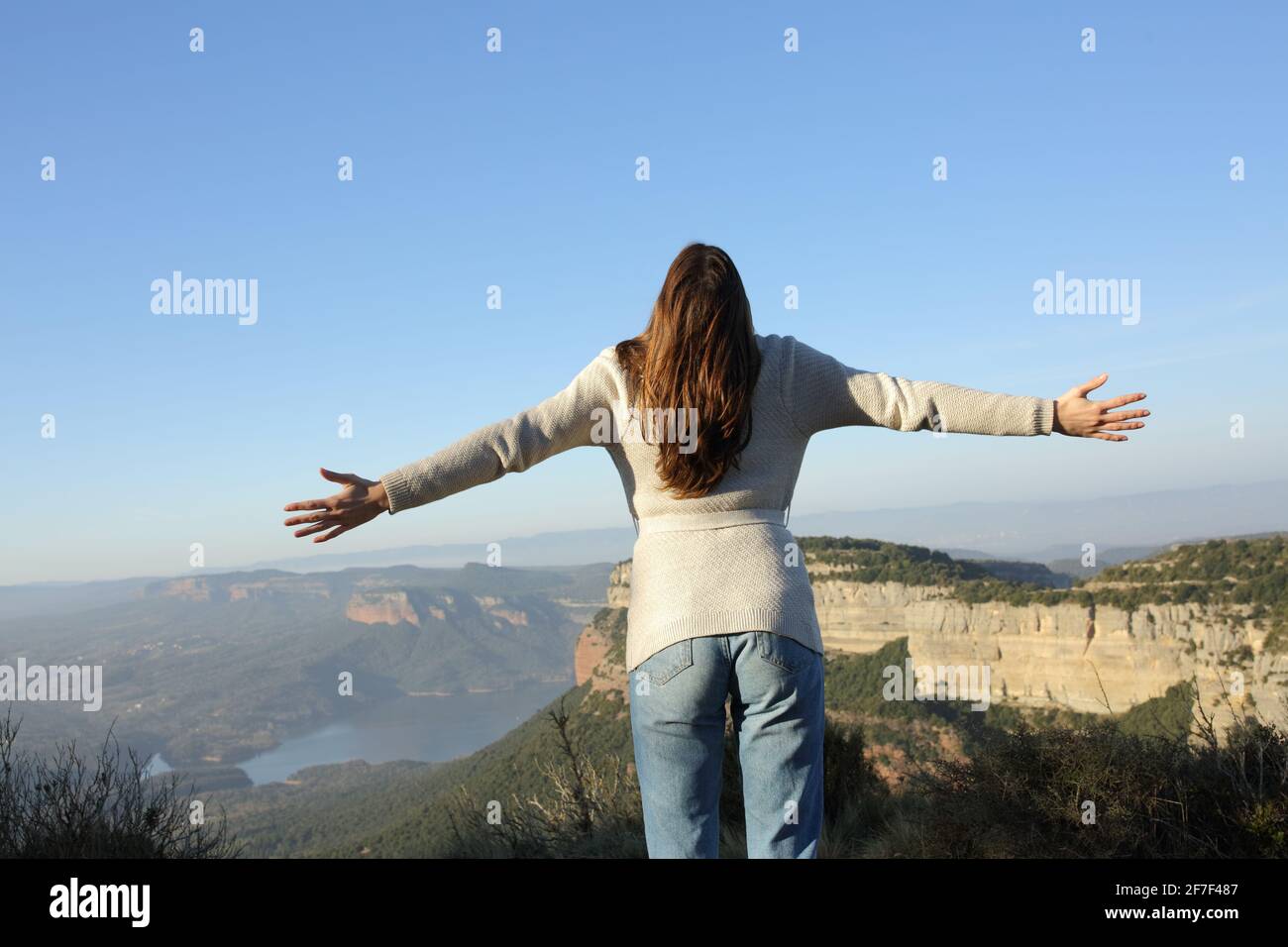 Vue arrière d'une femme célébrant la propagation de vacances avec ouvert bras dans la montagne Banque D'Images