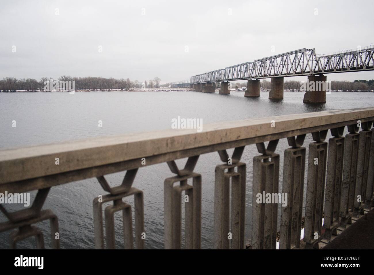 Pont ferroviaire au-dessus de la rivière Dnipro à Kiev. Pont en acier industriel de l'autre côté de la rivière. Banque D'Images