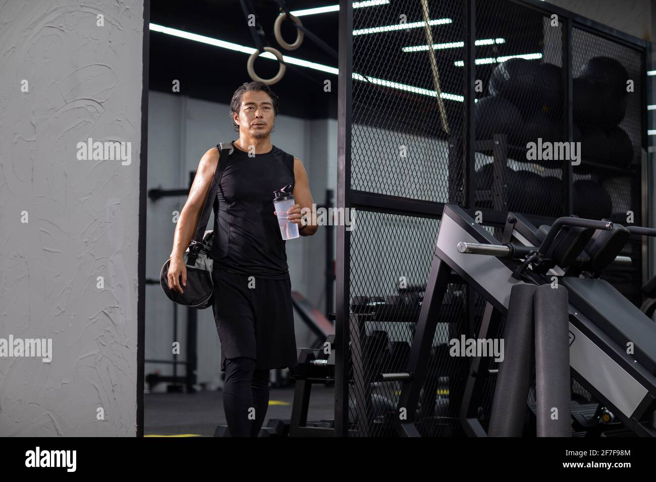 Homme mature avec sac de gym à la salle de gym Banque D'Images