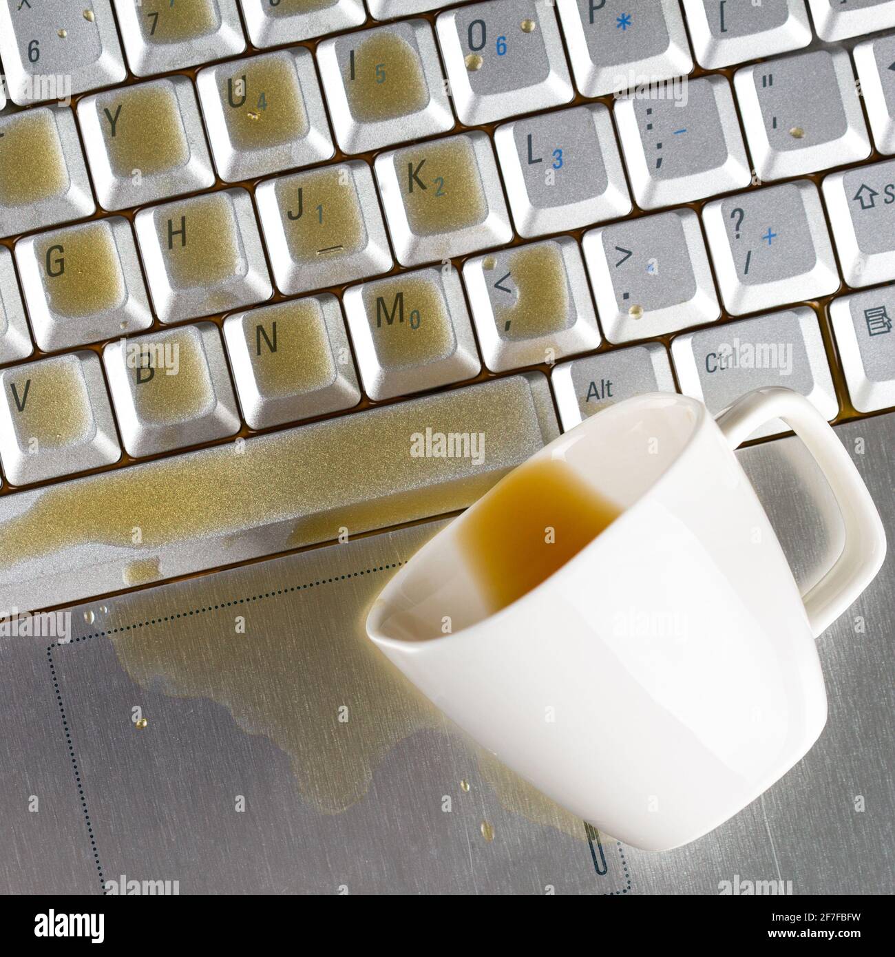 Café renversé sur le clavier de l'ordinateur portable en gros plan Banque D'Images Café renversé sur le clavier de l'ordinateur portable en gros plan Banque D'Images