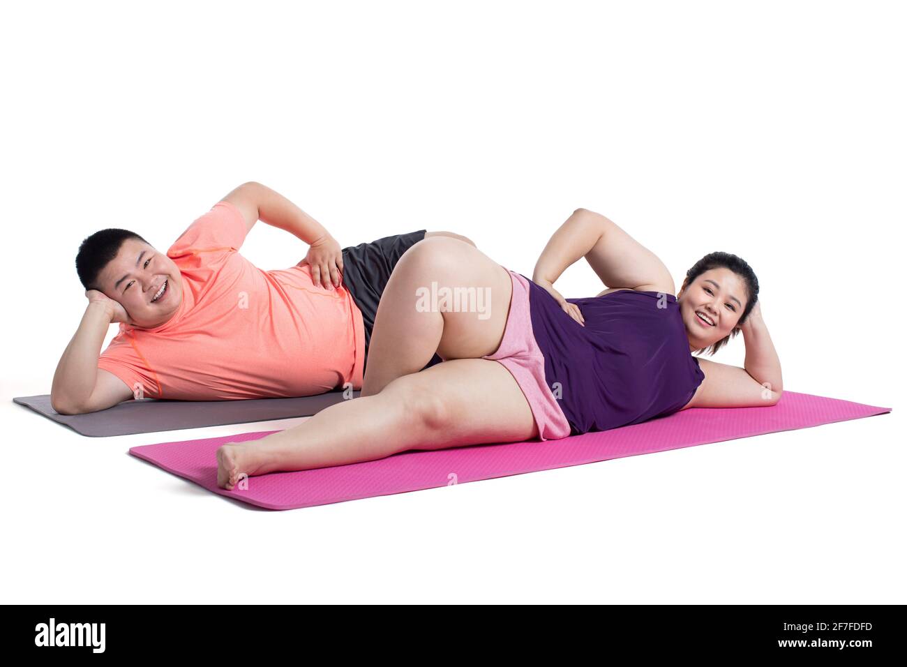 Jeune couple en surpoids allongé sur un tapis d'exercice Banque D'Images