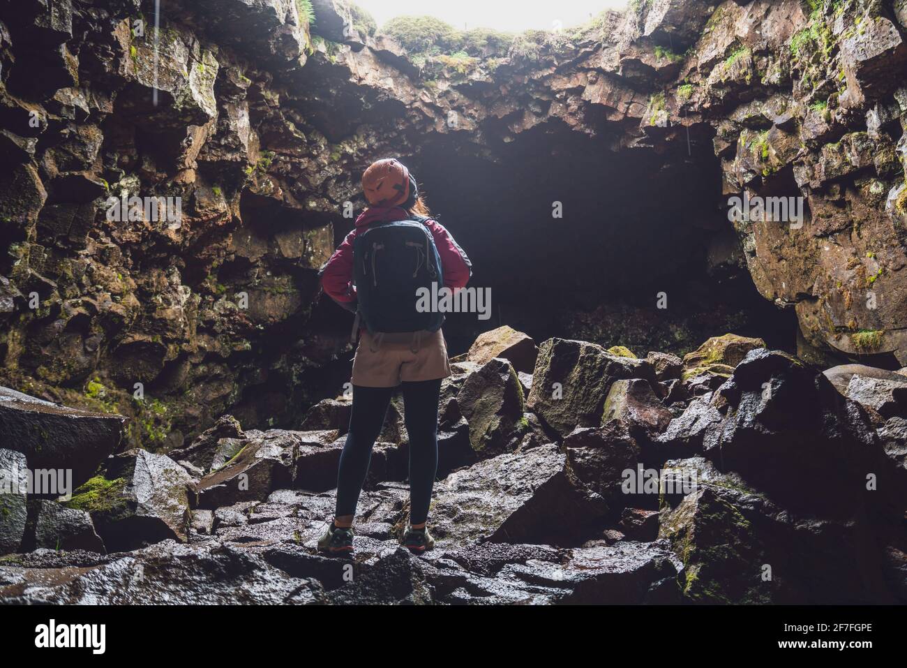 Une femme voyageur explore le tunnel de lave en Islande. Raufarholshellir est un beau monde caché de caverne. C'est l'une des plus longues et des plus connues lave Banque D'Images