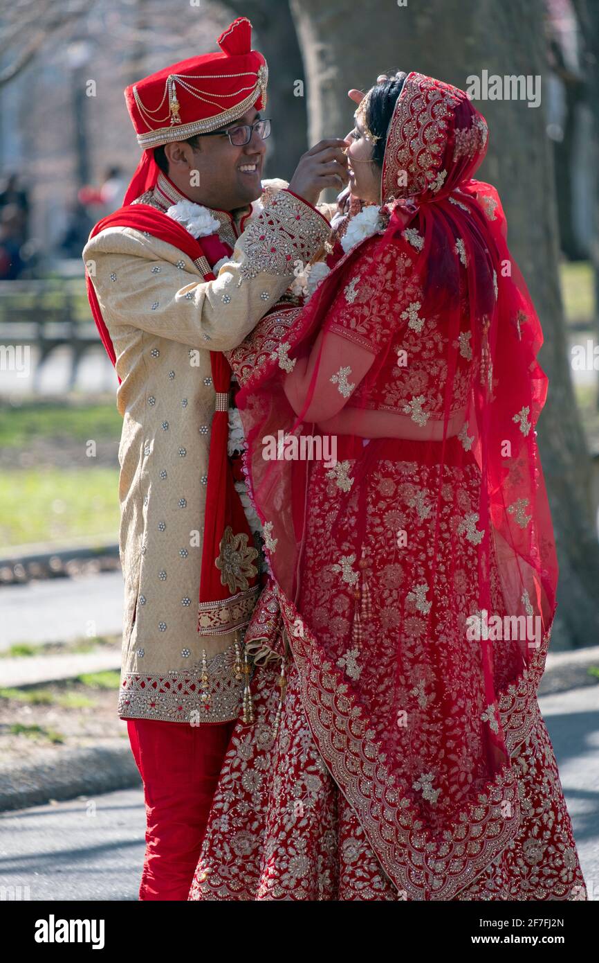 Un couple hindou en vêtements ethniques ornés pose pour des photos dans un parc à Queens, New York. Banque D'Images