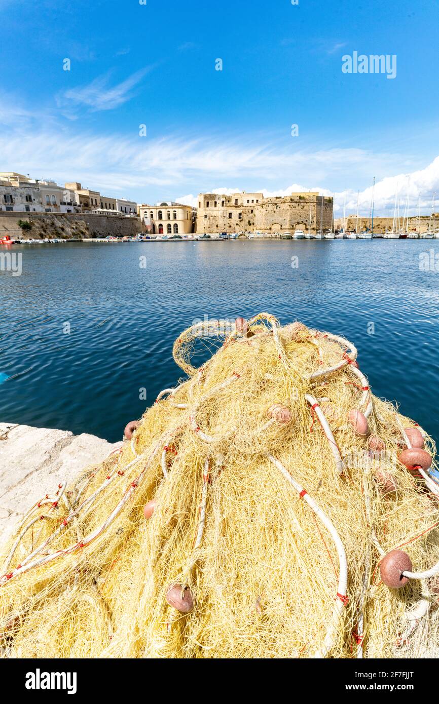 Filets de pêche dans le port entouré par la vieille ville et le château par la mer, Gallipoli, province de Lecce, Salento, Apulia, Italie, Europe Banque D'Images