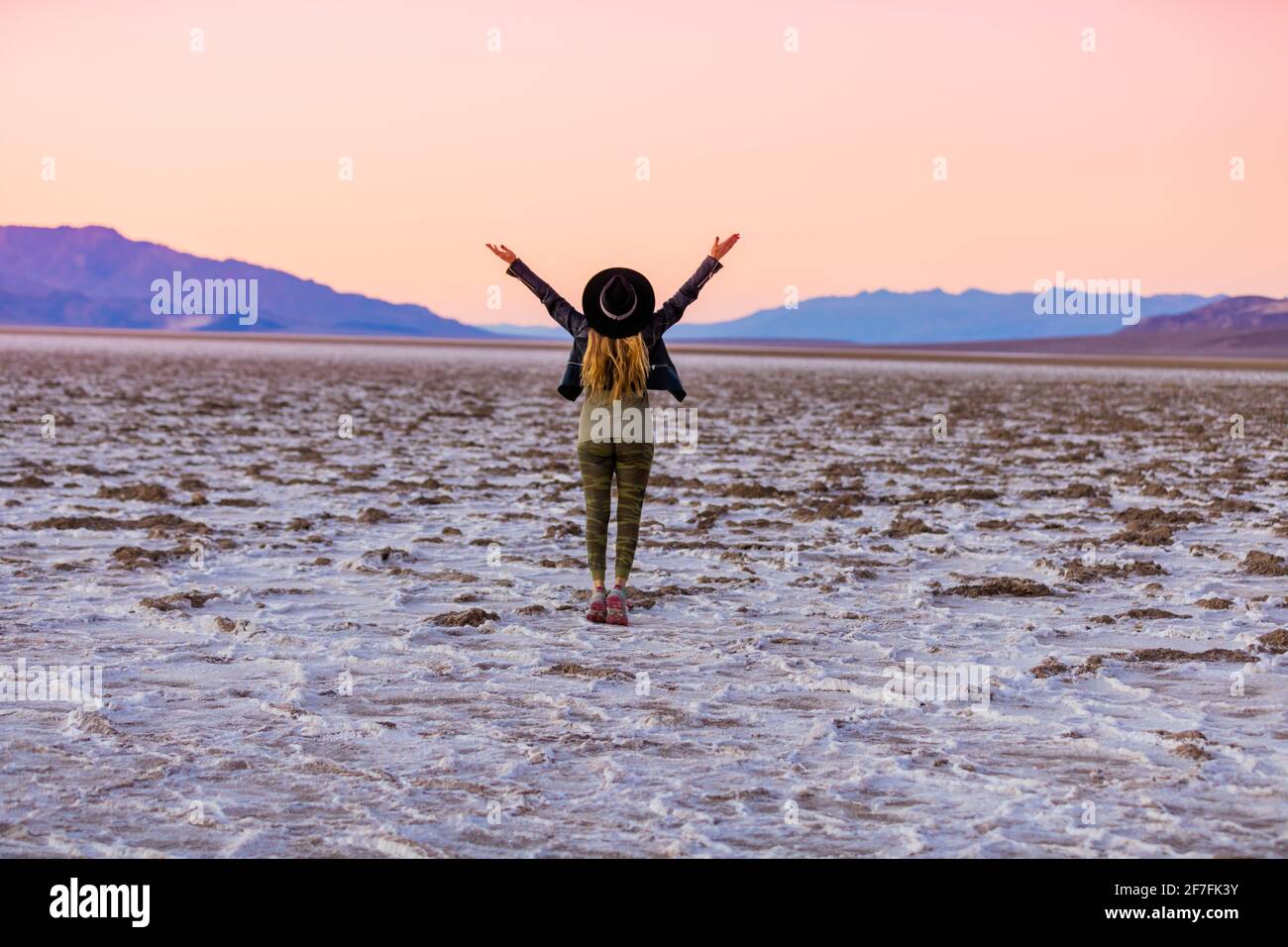 Modèle posant pour la caméra au coucher du soleil au-dessus des plats salés des dunes de Mesquite, Californie, États-Unis d'Amérique, Amérique du Nord Banque D'Images