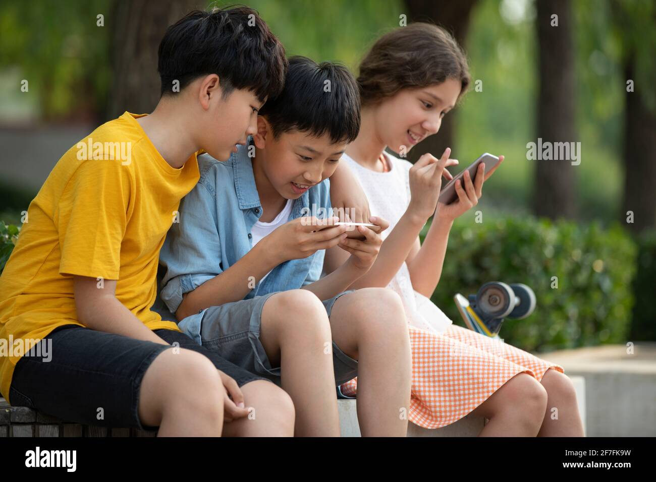 Adolescents utilisant un smartphone à l'extérieur Banque D'Images