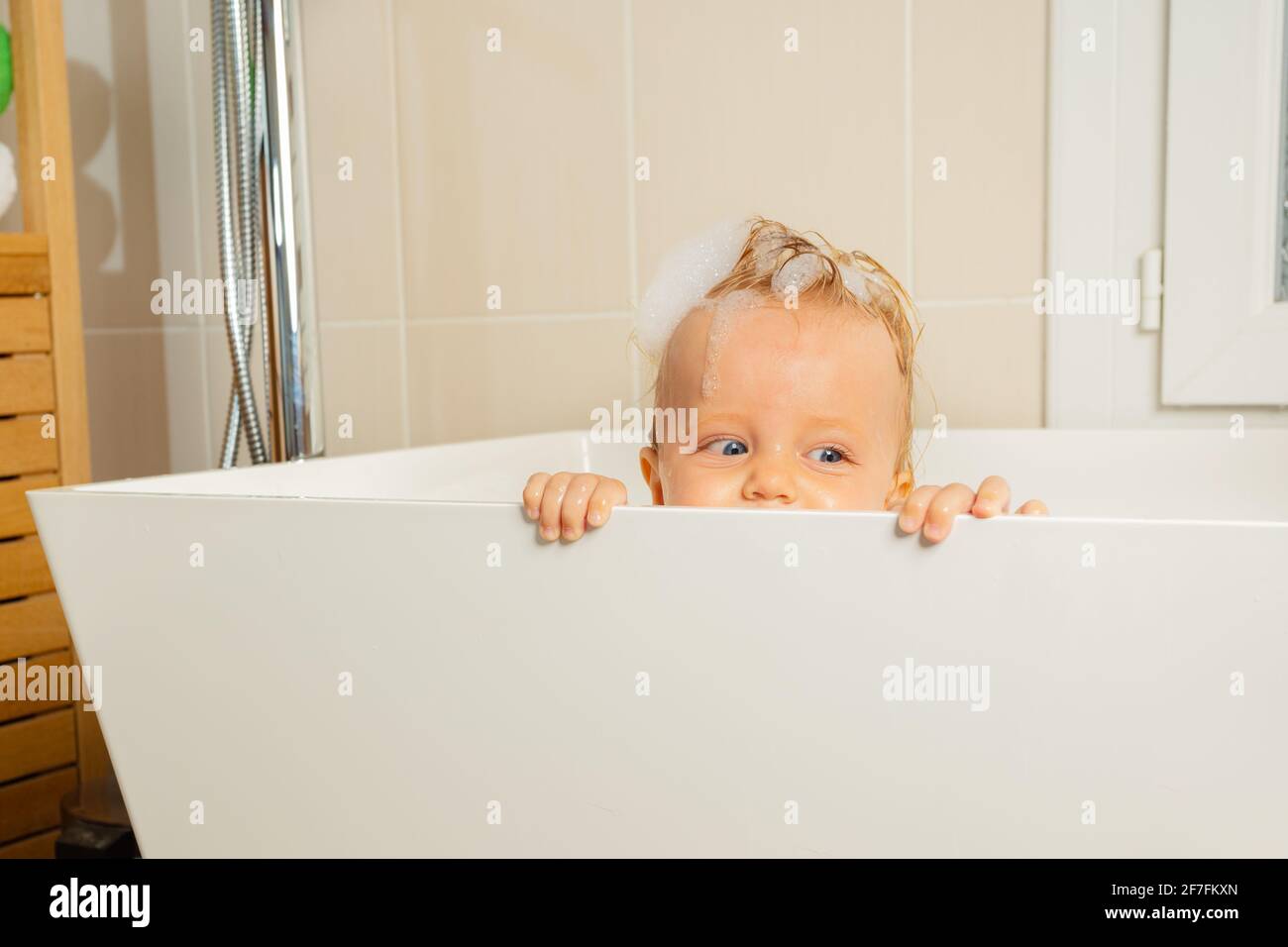 Un petit garçon joue à cache et cherche dans une baignoire Photo Stock -  Alamy
