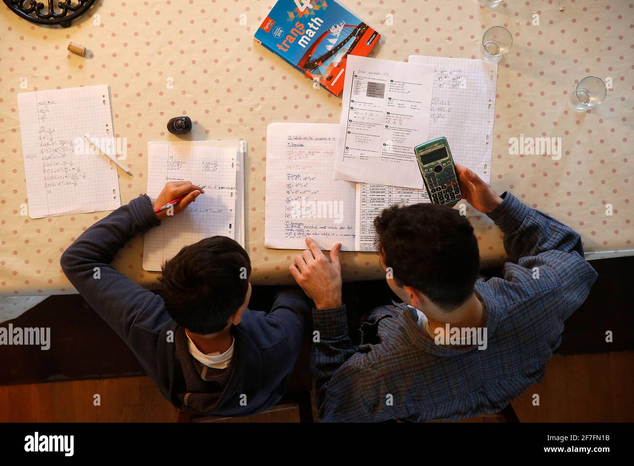 Jeune homme aidant un garçon avec ses devoirs à Montrouge, France, Europe Banque D'Images