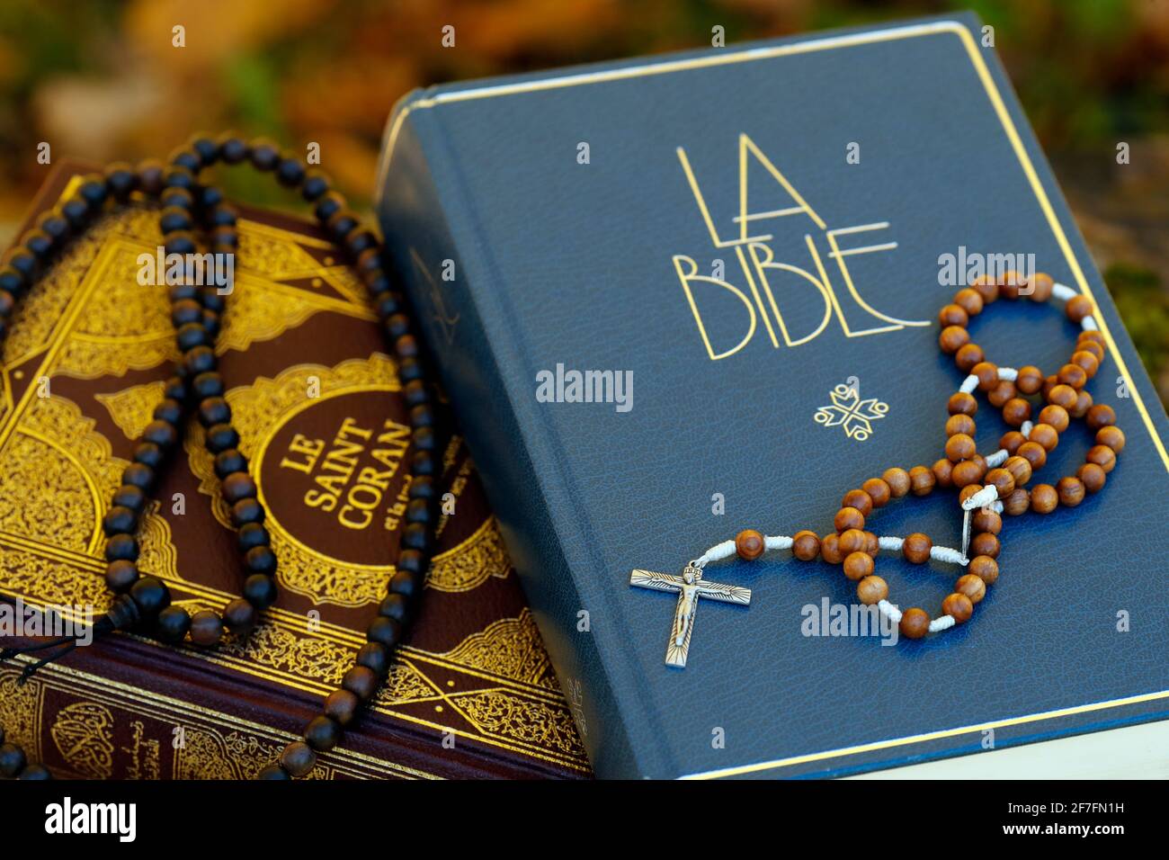 Saint Coran en français avec perles de prière musulmanes et Bible avec rosaire, symboles interreligieux entre le christianisme et l'islam, France, Europe Banque D'Images
