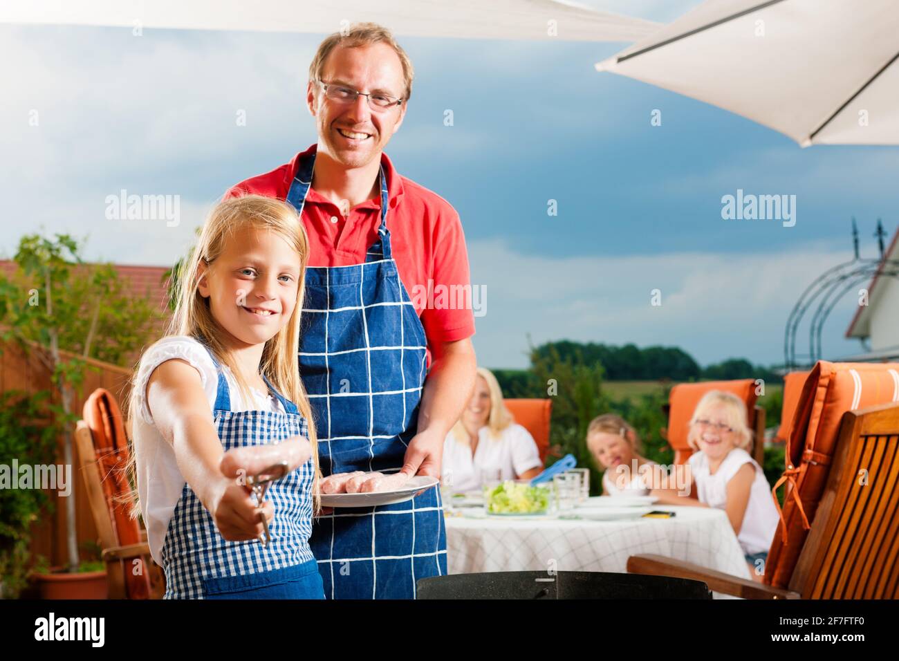 Happy Family having a barbecue en été ; le père et un enfant debout à la grill Banque D'Images