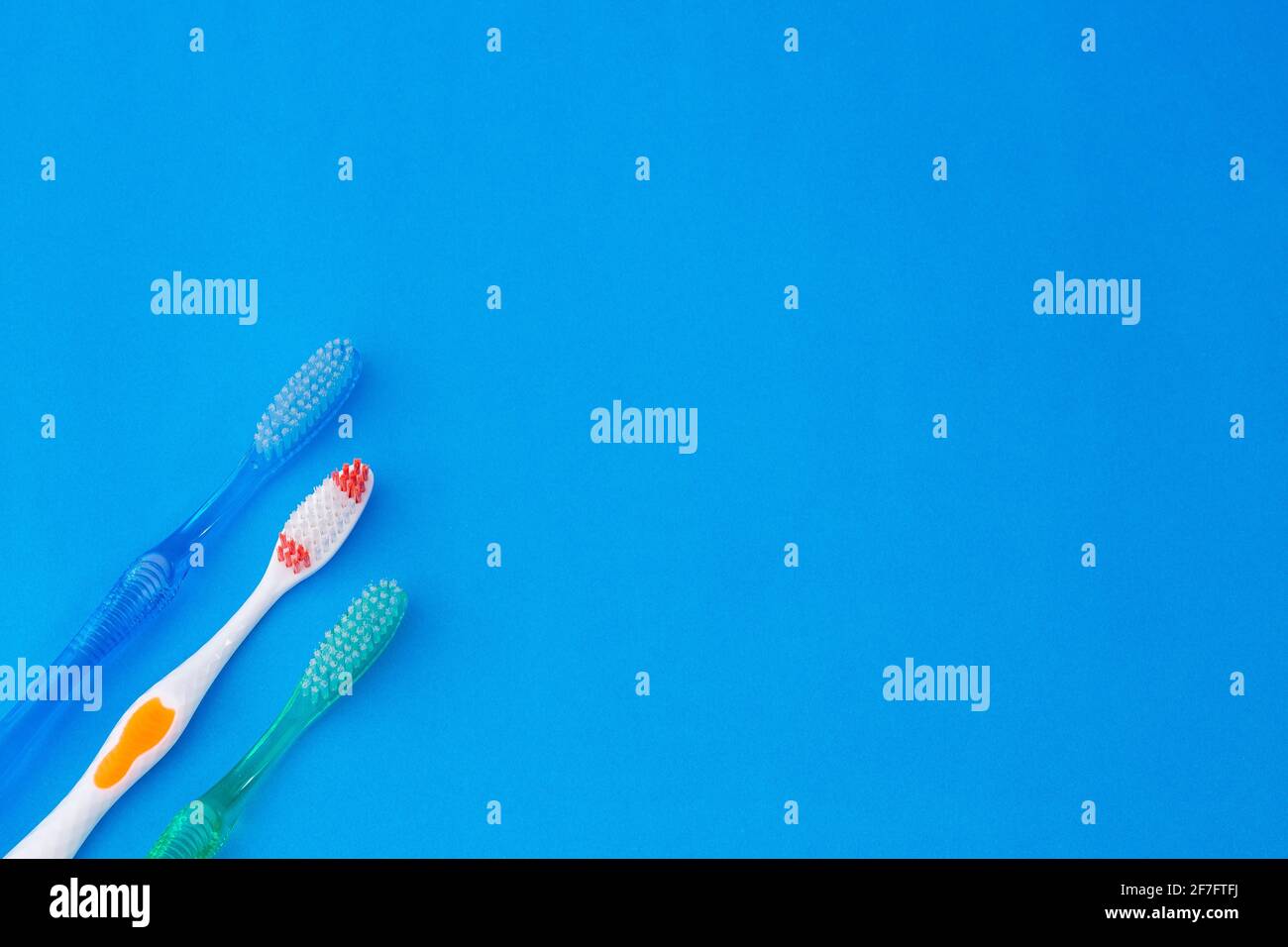 Trois brosses à dents sur fond bleu Banque D'Images