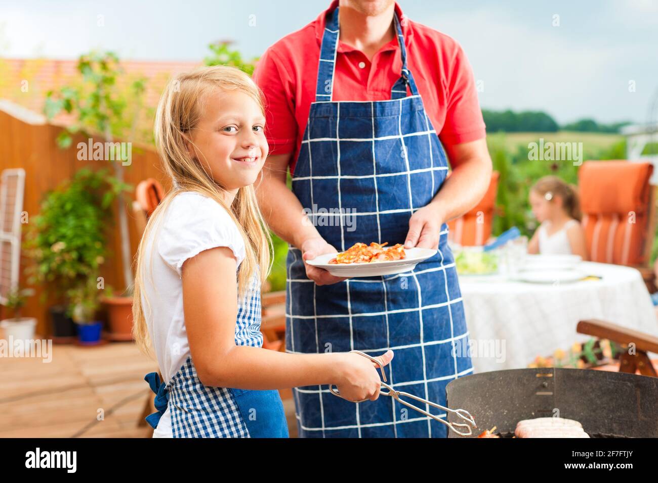 Happy Family having a barbecue en été ; le père et un enfant debout à la grill Banque D'Images