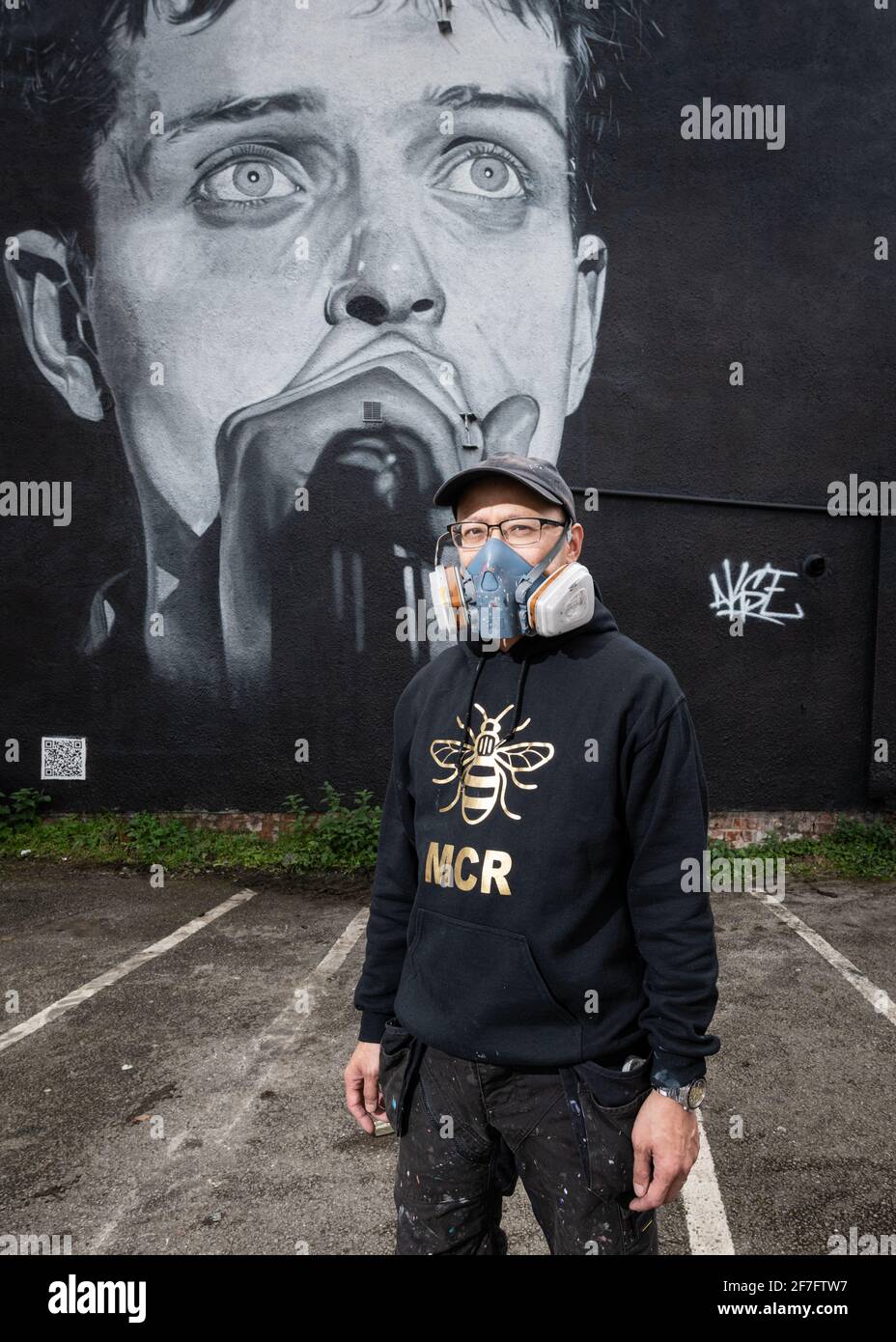 Akse, artiste de rue, se dresse devant sa fresque de Ian Curtis, le leader de Joy Division. Banque D'Images