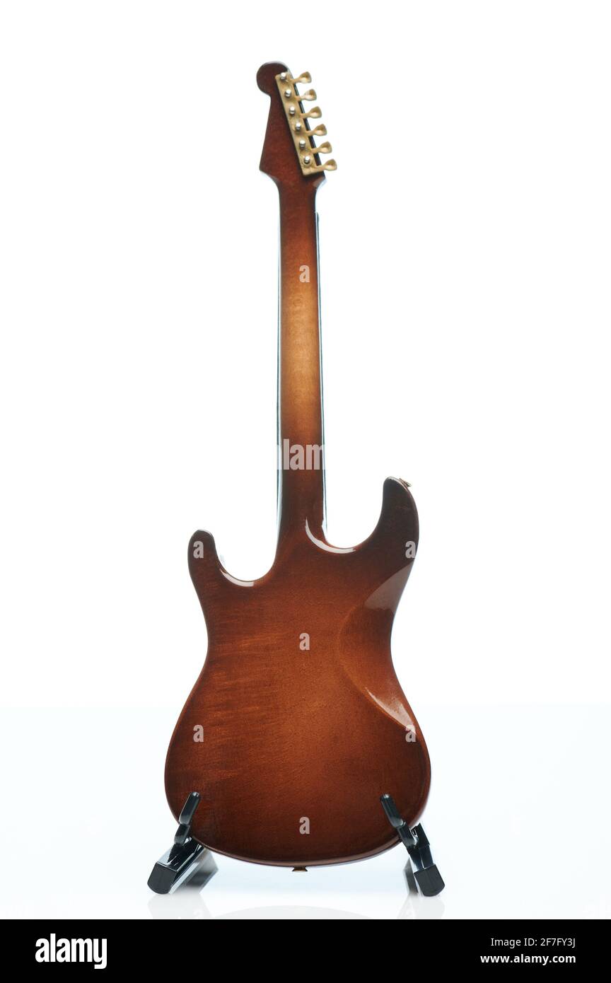 Guitare en bois marron sur un stand isolé sur un studio blanc arrière-plan Banque D'Images