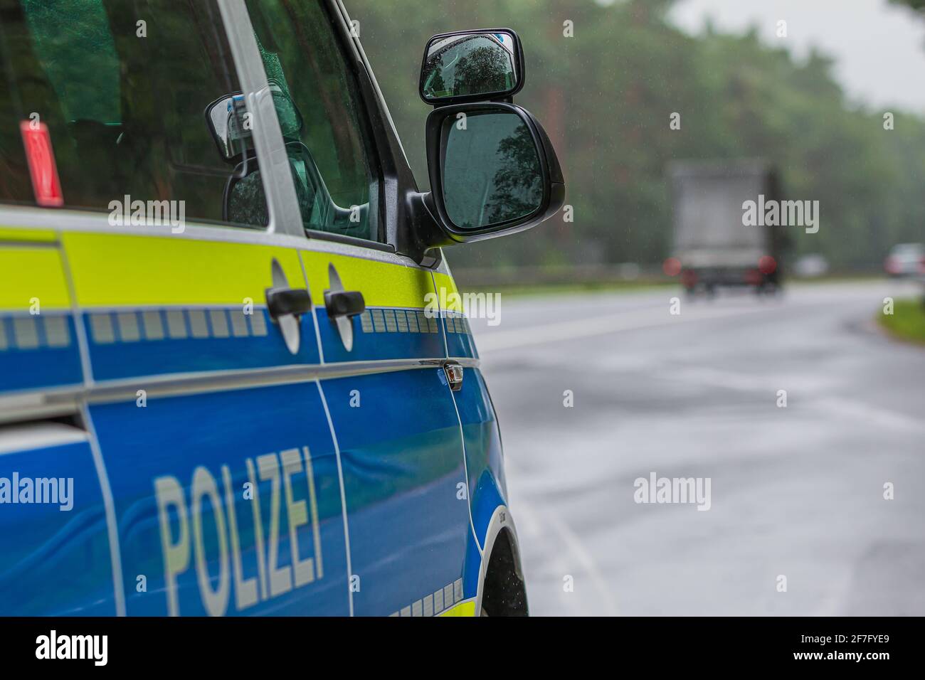 Vue latérale de la voiture de police allemande avec l'autoroute en arrière-plan. Miroir de glace du côté passager avec peinture jaune et bleue. Urgence b Banque D'Images